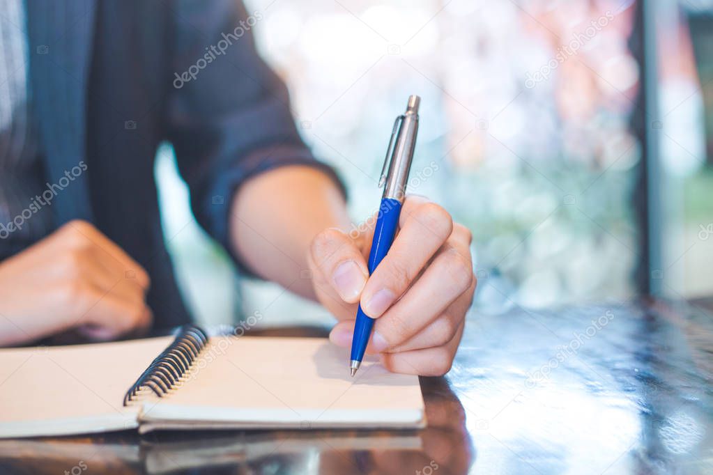 Business woman writing on a noteboo