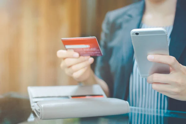 İş kadınları kullanım cep telefonu online kredi kartı ile alışveriş için el.