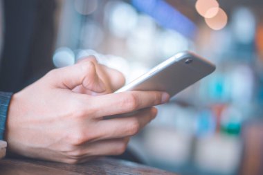 İş kadın el ofiste cep telefonu kullanıyorsunuz.