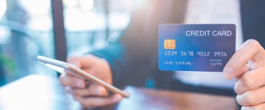 İş kadın el bir mavi kredi kartı ve cep telefonu kullanımı ofiste tutar. Web afiş.