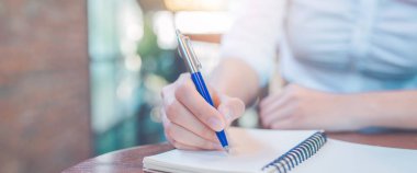 Kadın el ofiste bir kalem ile not etmek üstünde yazılı. Web afiş.