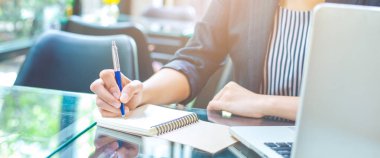 Kadın ofiste kalemle bir defter üzerinde yazma. Web afiş.