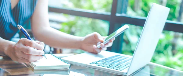 Business Kvinna Hand Skriva Ett Anteckningsblock Med Penna Och Mobiltelefon — Stockfoto