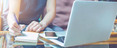 İş kadın eli kalemle not etmek üstünde yazıyor. Web afiş.