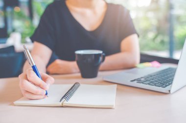 İş kadın eli bir defter üzerinde bir kalemle yazma.