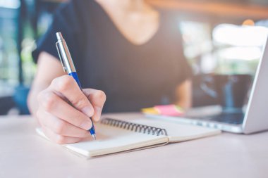 İş kadın eli bir defter üzerinde bir kalemle yazma.