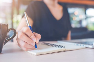 İş kadın eli bir defter üzerinde bir kalemle yazma.