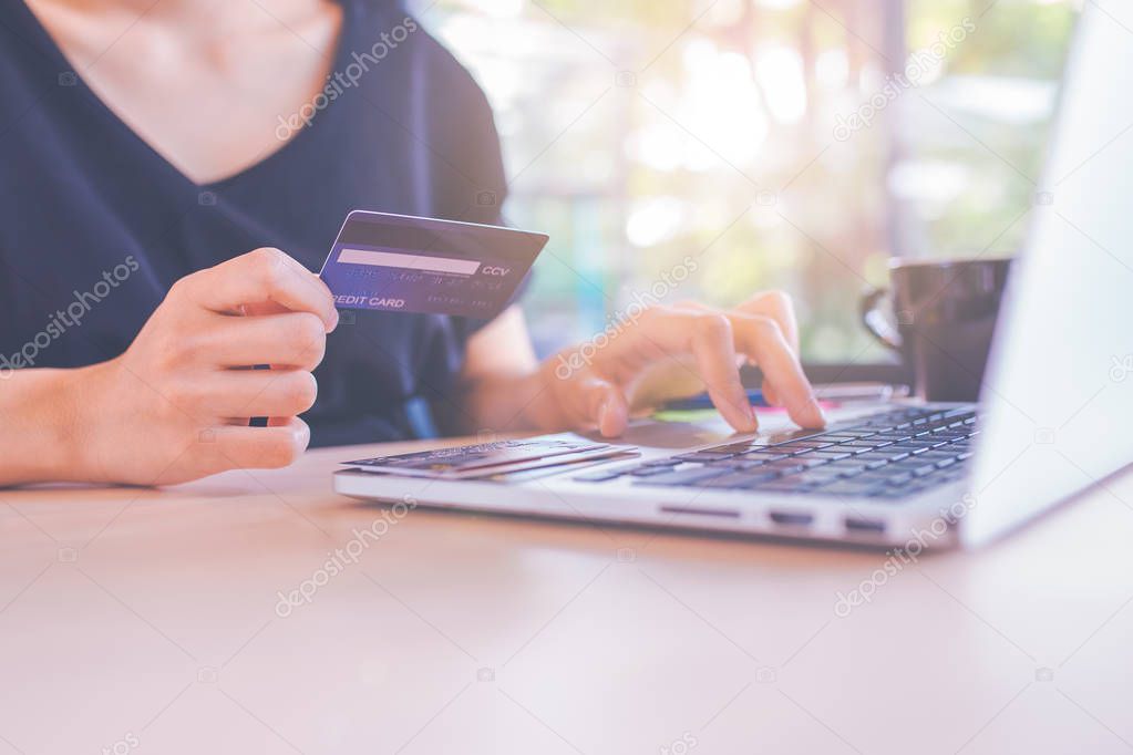 Business women use credit cards and laptop computers to shop onl