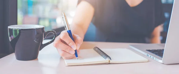 La mano de una mujer de negocios está escribiendo en un cuaderno con una pluma . — Foto de Stock