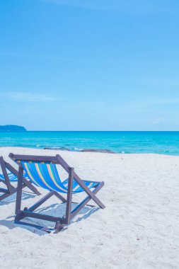 Deniz ve parlak gökyüzü ile plaj sandalyeleri ve köprüler
