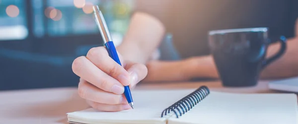 Nő kéz írás egy jegyzettömböt egy tollat hivatalban. Web Bann — Stock Fotó