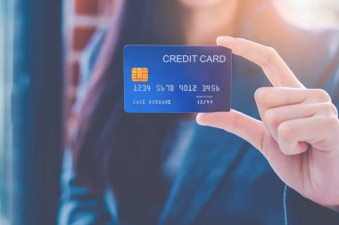 İş kadınları el mavi bir kredi kartı gösteriyor.