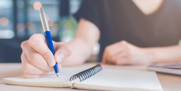 Frau schreibt mit Stift auf Notizbuch. — Stockfoto