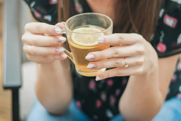 Kadınlar elinde limonla bir fincan çay tutuyorlar.