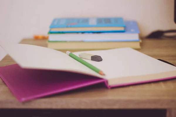 Masada kalemle birlikte kitaplar olan defter. 