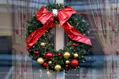 Noel çelenk dekore edilmiş kırmızı kurdele ve Noel süsleri.