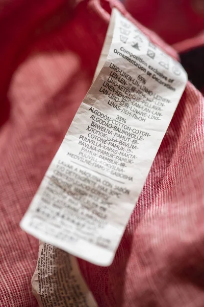 Etiket keten ve pamuk pembe gömlek içinde yıkama talimatları ile. 