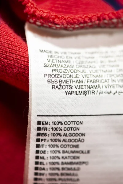 Label inside on red cotton shirt. Text 100% cotton on many languages.