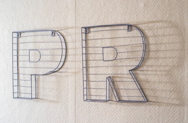 PR word on wall. Public Relations concept with 3D letters PR made of stone.