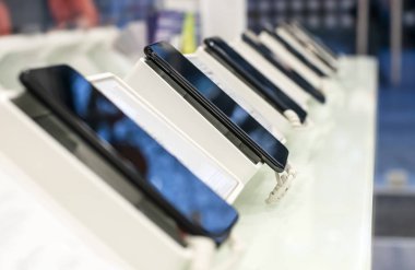 Mağaza raf üstünde hareket eden telefon. Yakın çekim smartphones içinde bir dükkan. İletişim teknolojisi ve ticari kavramı.