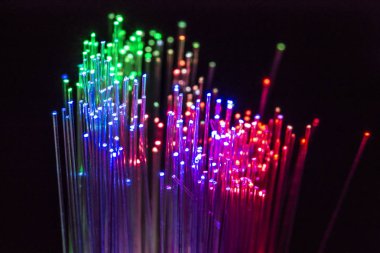 Renkli optik lifler üzerinde koyu arka plan aydınlatılmış. Yüksek hızlı Internet kavramı. Optik fiber kablo baðlamanýz gerekebilir. Birçok optik lifler, farklı renkleri parlayan bir grup. Teknolojik altyapı.
