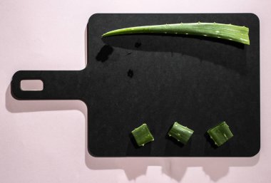 Aloe vera dilimleri karanlık gemide. Sağlık ve güzellik kavramı. Closeup aloe yaprak backlight üstünde kesmek..