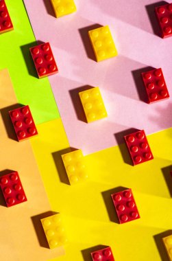 Plastik geometrik küpleri. Geometrik şekiller inşaat oyuncaklar çok arka plan renkli kağıt. Satırları düzenlenmiştir. Çocuk oyuncağı. Daire geometrik şekillerin üzerindeki plastik tuğla. 