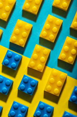 Plastik geometrik küpleri. Geometrik şekiller inşaat oyuncaklar çok arka plan renkli kağıt. Satırları düzenlenmiştir. Çocuk oyuncağı. Daire geometrik şekillerin üzerindeki plastik tuğla. 