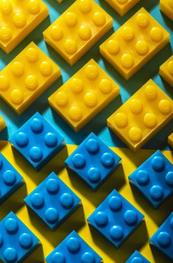 Plastik geometrik küpleri. Geometrik şekiller inşaat oyuncaklar çok arka plan renkli kağıt. Satırları düzenlenmiştir. Çocuk oyuncağı. Daire geometrik şekillerin üzerindeki plastik tuğla. 