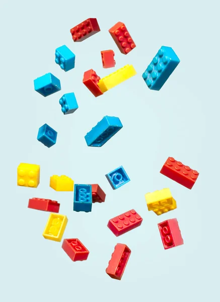 Plastik geometrik küpleri havada yüzer. Geometrik şekiller çekimde düşmek inşaat oyuncaklar. Mavi pastel renkli. Çocukların oyuncakları. Daire geometrik şekillerin üzerindeki plastik tuğla.
