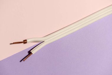 Elektrik kablo üzerinde pastel pembe. Bakır teller yayılır. Minimalist elektrik arka plan.