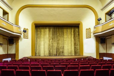 Tiyatro iç. Sarı perde. Tiyatro iç kırmızı koltuklarda. Vintage klasik sahne. Sanat performansı. Görsel Sanatlar için kavram. Zâviye kitle için iki katlıdır. Sarı duvarlar. 