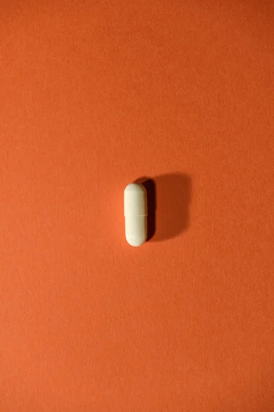 Ένα Λευκό Χάπι Πορτοκαλί Φόντο Μινιμαλιστική Αντίληψη Για Την Ιατρική — Φωτογραφία Αρχείου