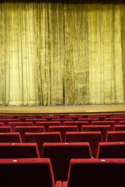 Theater interior. Yellow curtain. Red seats in theater interior. Vintage classic scene. Art performance. Concept for visual arts. Two floors with lodges for the audience. Yellow walls.