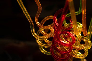 İçme suları için renk tüpleri. Bir spiral şeklinde kavisli. Parlak arka plan bulanık festival atmosferi iletir