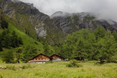 Avusturya Alpleri 'nde Grossglockner kaya zirvesi yakınlarındaki kayalık dağlarla çevrili güzel Tyrolean evleri, Kals am Grossglockner, Avusturya