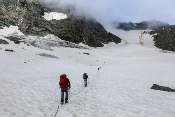 Alpinisté Zasněžené Trase Obklopeni Skalnatými Horami Mlze Rakouských Alpách Poblíž — Stock fotografie