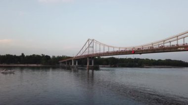 Trukhaniv adası ve Ukrayna 'nın Kyiv şehrindeki Dnipro nehri üzerindeki yaya köprüsü manzarası. Dinyeper, Avrupa 'nın en büyük nehirlerinden biridir ve Ukrayna' nın en uzun nehridir.