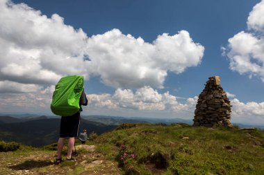Dağlar taş yığınları ve turistler yolu takip ediyor, ufuktaki mavi gökyüzü. Yürüyüş konsepti panoramik görünüm