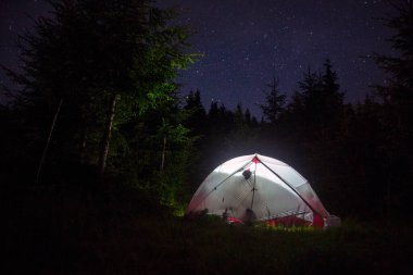 Geceleri kamp çadırı aydınlatılıyordu. Ormanı yıIdızlarla kaplayan karanlık gece göğü.
