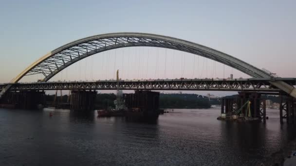 Construction d'un nouveau pont à voûte traversant la rivière Dnipro (Dniepr), Kiev, Ukraine. Coucher de soleil sur la grande installation d'infrastructure sur l'eau