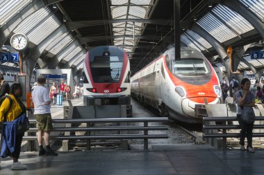 Zürih, İsviçre - 1 Ağustos 2019: turistler istasyondaki modern İsviçre ulaşım trenlerinin yanında bekliyorlar