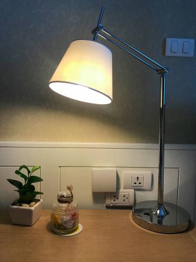 Yıldırım lamba prizler, toffee şeker şişe ve küçük bitki pot ile çalışma masasında