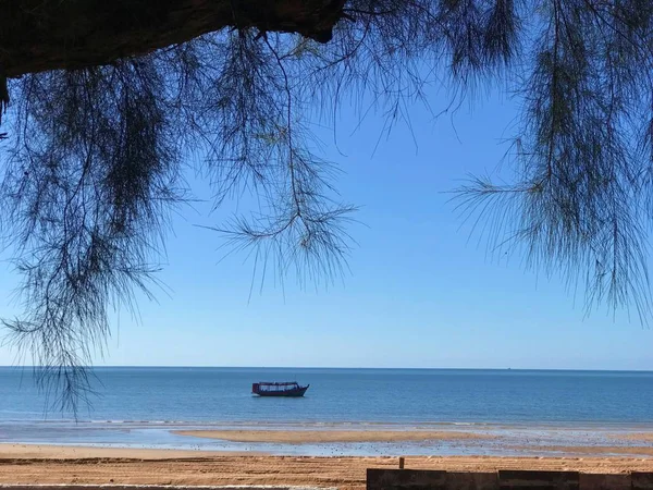 木の枝とタイ南部の空青い水平線までビーチから撮影 ビーチ近くに浮かんでいる小さなボート — ストック写真