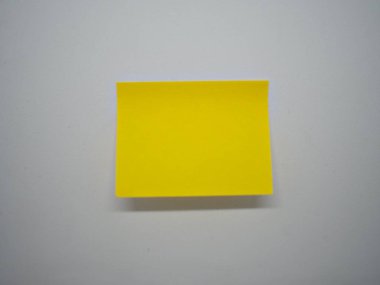 Yapışkan notu sopa altındaki küçük bir shadown izole beyaz duvar üzerinde