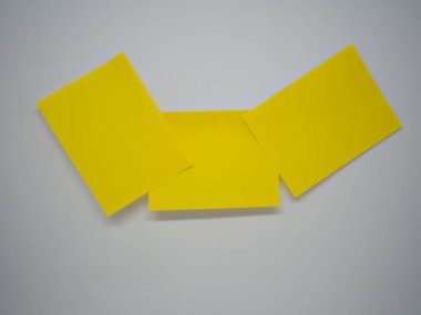 Üç sarı yapışkan notlar birbirlerine beyaz izole arka plan üzerinde yalan