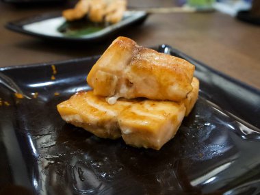 Izgara Japon somon dekore edilmiş siyah plaka üzerinde