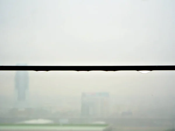 The rain drop on the iron fence with heavy rain background