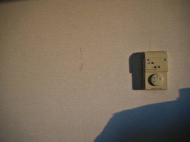 Bir analog hava durumu termostat sabah güneş ışığı touch iken gölge duvar üzerinde