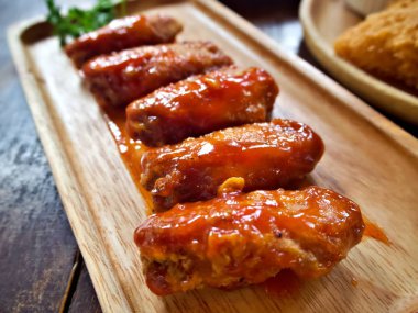 Dekore maydanoz ile ahşap plaka üzerinde Kore tarzı kızarmış tavuk kanadı